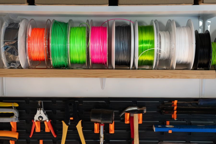 Wand vol filamentkleuren in onze werkplaats